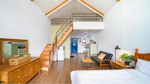 a living room with a bed and a staircase at Tongyeong Maremio Oceanview Pension in Tongyeong