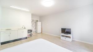 a white room with a kitchen and a refrigerator at Pocheon Swimpyo Pension in Pocheon