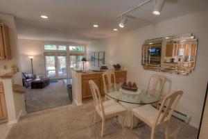 Una cocina y un comedor con una mesa de cristal y sillas. en Delightful McCloud condo, en Incline Village