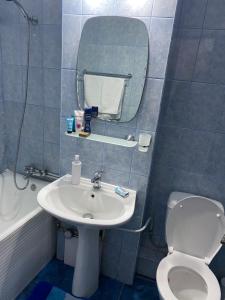 a bathroom with a sink and a toilet and a mirror at Studio Lotus Zalău in Zalău