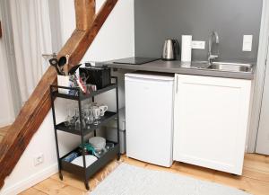 a kitchen with a white refrigerator next to a sink at Studio mit Panoramablick in Flensburg