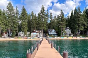 a wooden bridge over a lake with houses and trees at Zephyr Cabin home in Zephyr Cove