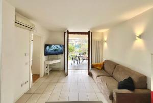 a living room with a couch and a television at Garden Thermae in Nago-Torbole