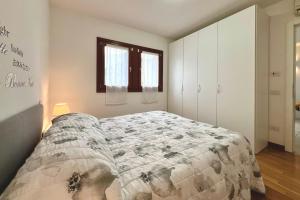 a bedroom with a bed with a quilt on it at Garden Thermae in Nago-Torbole