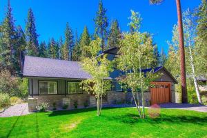 a house with a green yard with two trees at Creek Side Summit home in Stateline