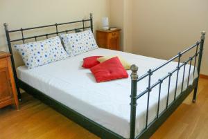 a bed with red pillows on it in a room at Le Corti in Cannobio