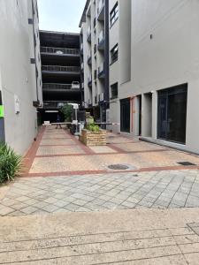 une cour vide dans un immeuble avec des bâtiments dans l'établissement UrbanParkezstay i008, à Durban