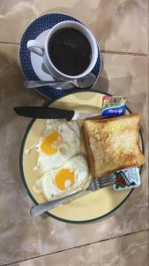 a plate with eggs and toast and a cup of coffee at Warung Santai Bali Jimbaran in Uluwatu +10 photos