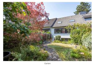 una casa con un jardín delante de ella en Cozy basement guest room in quietness, en Hannover