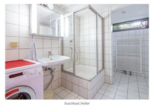 Un baño con lavadora y lavabo. en Cozy basement guest room in quietness, en Hannover