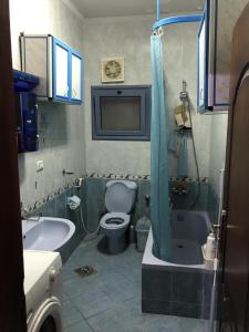 ein Badezimmer mit Toilette, Badewanne und Waschbecken in der Unterkunft شقه مفروشه للايجار التجمع الخامس النرجس in Kairo