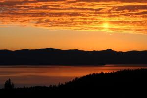 a sunset over a body of water with mountains at Lakescape condo in Stateline