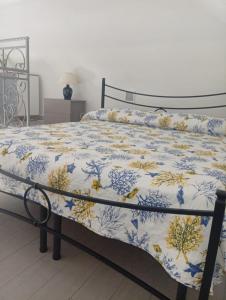 a bed with a blue and white comforter at Cantone Studio On The Beach in Cetara