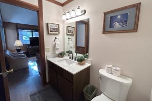 Un baño con inodoro, lavabo y espejo. en Brookstone Pines home, en Incline Village