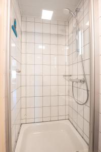 a bathroom with a shower with white tiles at Nice apartment with suberb Sea Views in De Haan +22 photos