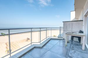 a balcony with a bench and a view of the beach at Nice apartment with suberb Sea Views in De Haan