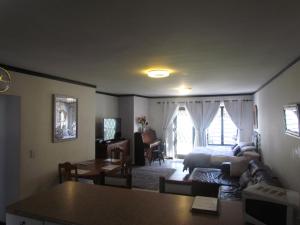 a living room with a couch and a table at Santini Lace Self Catering Unit in Plettenberg Bay