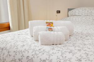 a pile of towels sitting on top of a bed at A8 Aloe Fiera Rho -Monza-Como-MXP AMPIO&LUMINOSO MONOLOCALE in Cesate