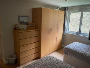 a bedroom with a bed and a dresser and a window at Portpatrick 2 bedroom Self Catering Flat in Portpatrick