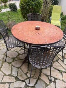 a red table with chairs and a ball on top at Maison cosy proche Paris-Orly in Vigneux-sur-Seine