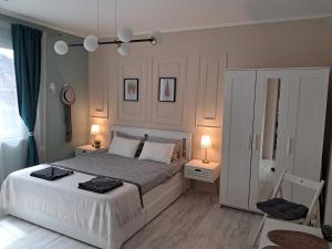 a bedroom with a large bed with two tables and two lamps at Varna Moreto in Varna City +19 photos