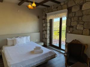 a bedroom with a bed and a large window at Bademli Han Otel in Ulucak