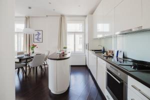 uma cozinha branca com uma mesa e uma sala de jantar em Prague Days - Stylish Apartment - Netflix - Hip District em Praga