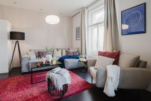 uma sala de estar com dois sofás e um tapete vermelho em Prague Days - Stylish Apartment - Netflix - Hip District em Praga