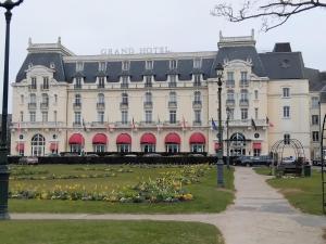a large building with a park in front of it at Appartement refait à neuf en 2025 in Cabourg