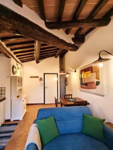 Una sala de estar con un sofá azul y una mesa. en La Tana del Priore, en Perugia