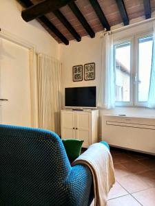 Una sala de estar con un sofá y un televisor. en La Tana del Priore, en Perugia