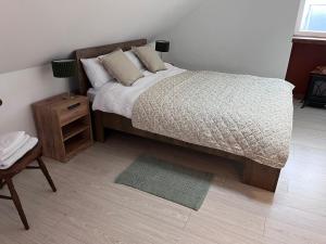 um quarto com uma cama e uma mesa de cabeceira e uma cama sidx sidx sidx em Top Deck em Killorglin