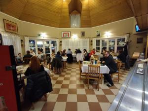 a group of people sitting at tables in a restaurant at Romantik Panzió in Bük