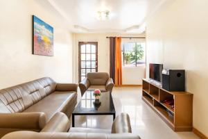 a living room with a couch and a television at Laciaville Resort and Hotel Inc in Lapu Lapu City