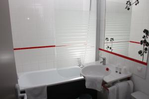a bathroom with a white tub and a sink and a bath tub at Motel du Val André in Pléneuf-Val-André