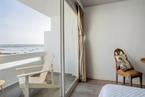 a bedroom with a bed and a chair and a window at Formentera Especial in La Savina