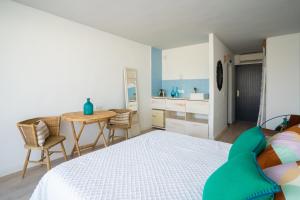 a bedroom with a bed and a table and a kitchen at Formentera Especial in La Savina