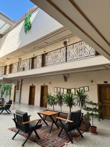 a patio with tables and chairs and a balcony at Bademli Han Otel in Ulucak