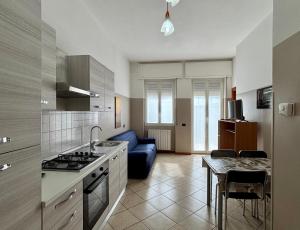 a kitchen and living room with a blue couch at Residence Oasi Di Monza in Monza