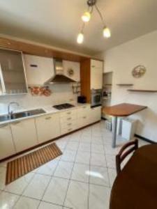 a large kitchen with white cabinets and a table at Casa Fabrizio in Villa Viani