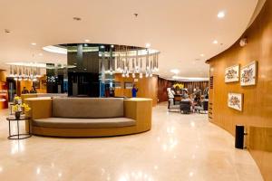 マニラにあるUnistay SHORE Residence w Balcony Amazing Manila Bay view near MOAの建物の真ん中にソファのあるロビー +80枚の写真