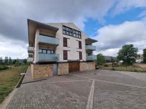 a large white building with a parking lot at Apartamento en Alcala de la Selva by Family Homes in Alcalá de la Selva