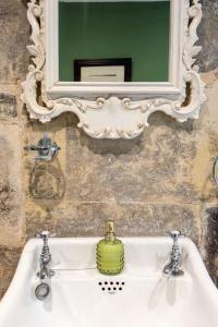 a bathroom sink with a mirror and a green soap at Chez Nous - central Maisonette - Bath Surrounds in Bradford on Avon +26 photos