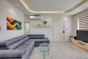 a living room with a couch and a television at The Marylou penthouse in Mġarr