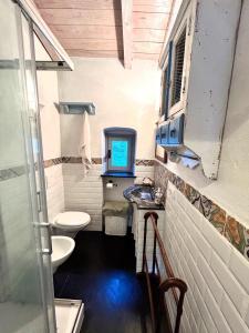 a small bathroom with two toilets and a tv at San Fruttuoso Amazing Cottage in San Fruttuoso