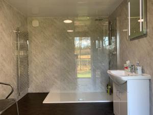 a bathroom with a tub and a sink and a shower at North Lodge Glamping in Carnwath