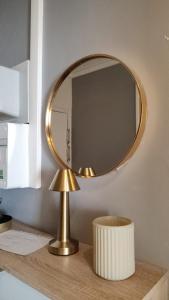 a gold mirror on top of a wooden table at Studio Nimes - Clim - Wifi -Cuisine privatif - salle de bain commune- balcon in Nîmes