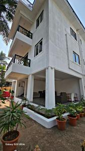 un gran edificio blanco con plantas delante en White Threads Vagator Goa, en Anjuna