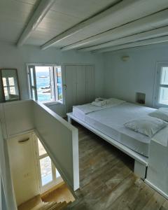 a bedroom with a large bed and two windows at Folegandros Villas Beachfront in Karavostasi +19 photos