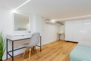 Cette chambre blanche dispose d'un bureau et d'une chaise. dans l'établissement Palanga Beach Apartments Daukanto, à Palanga